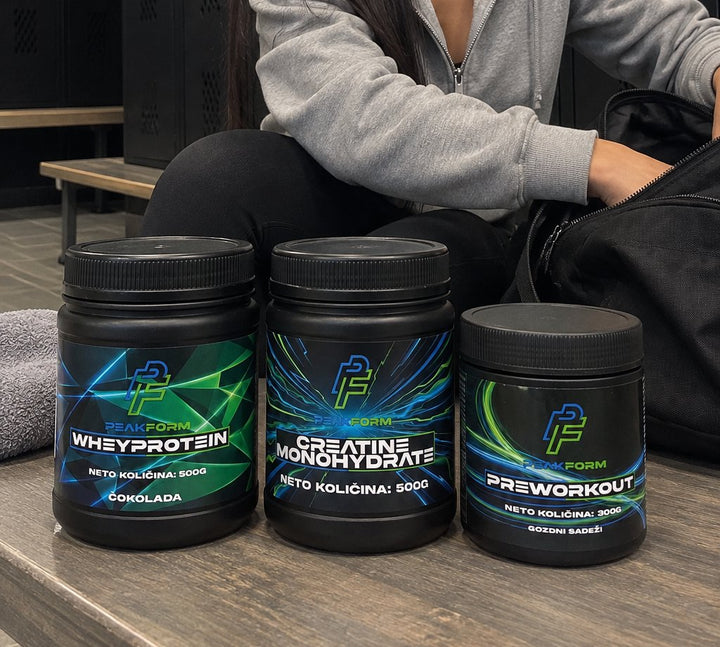 PeakForm whey protein, kreatin monohidrat in pre-workout na klopi v garderobi ob športni torbi